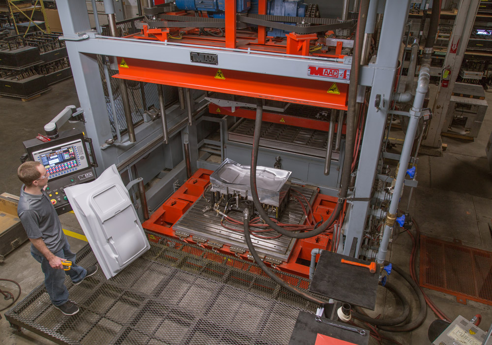 Operator running a MAAC thermoforming press on the production floor